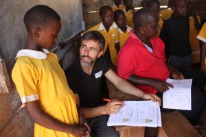 Imagen 1. Actualizando las fichas escolares de las alumnas becadas. Aquí en Kiyindi Communitty Primary School